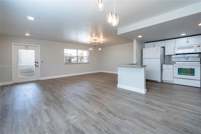 494 Monaco K Unit 494, Delray Beach, FL 33446 - kitchen featuring a notable chandelier, baseboards, white appliances, backsplash, and light wood-style floors