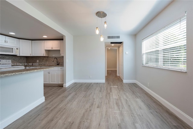 494 Monaco K Unit 494, Delray Beach, FL 33446 - kitchen featuring visible vents, white cabinets, baseboards, white appliances, and backsplash