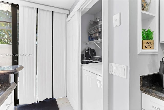 laundry area with washing machine and clothes dryer, tile patterned flooring, and laundry area