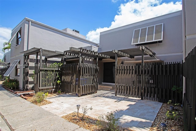 view of gate featuring a pergola and fence