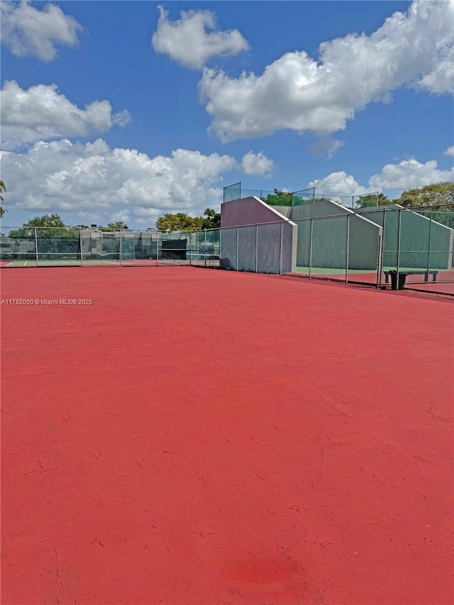 exterior space featuring a tennis court and fence