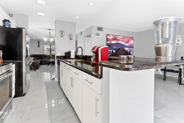 kitchen featuring visible vents, a sink, open floor plan, appliances with stainless steel finishes, and marble finish floor