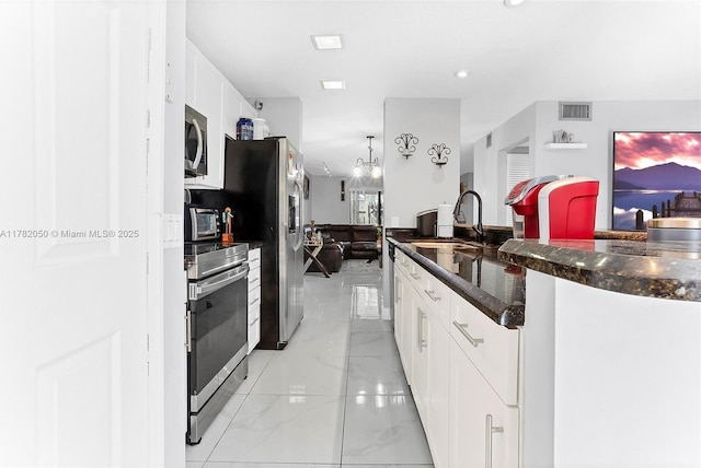 kitchen with visible vents, white cabinets, appliances with stainless steel finishes, marble finish floor, and a sink
