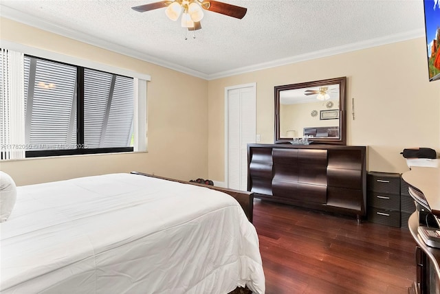 bedroom featuring dark wood-style flooring, a textured ceiling, crown molding, and a ceiling fan