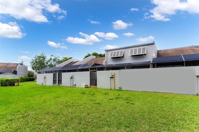 back of property featuring a yard, a wall mounted air conditioner, and stucco siding