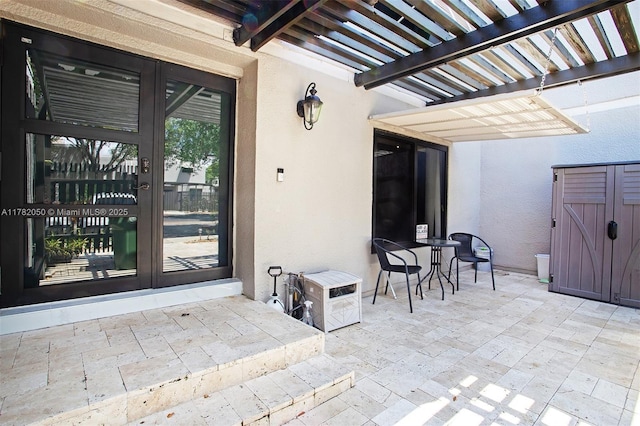 view of patio with a pergola, french doors, an outbuilding, and a storage unit