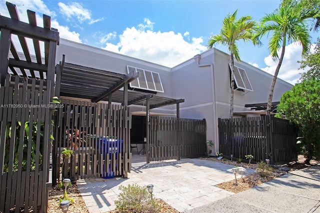 view of gate featuring fence and a pergola