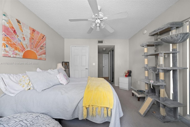 carpeted bedroom with ceiling fan, baseboards, a textured ceiling, and visible vents