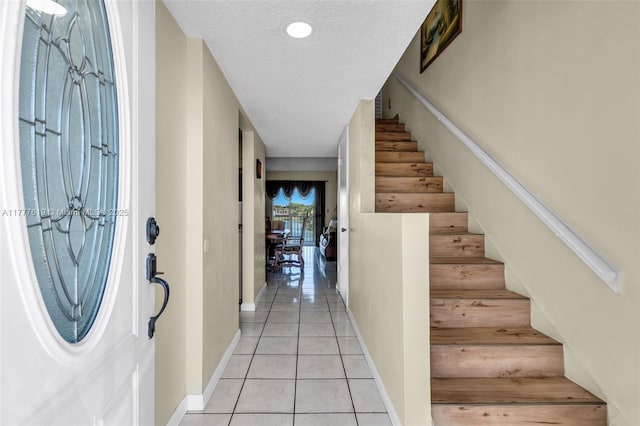 300 NW 107th Ave Unit 201, Miami, FL 33172 - entrance foyer with stairway, a textured ceiling, baseboards, and light tile patterned floors