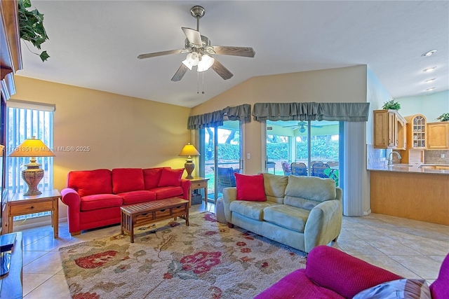 tiled living room featuring a sink, ceiling fan, and vaulted ceiling