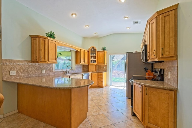 kitchen featuring vaulted ceiling, a peninsula, light tile patterned flooring, visible vents, and appliances with stainless steel finishes