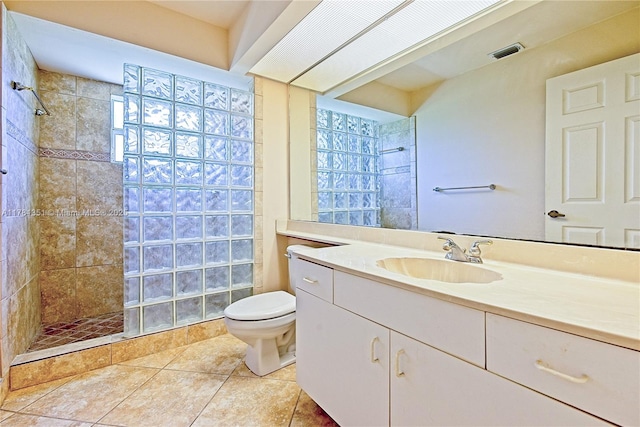 bathroom featuring visible vents, toilet, a walk in shower, vanity, and tile patterned flooring