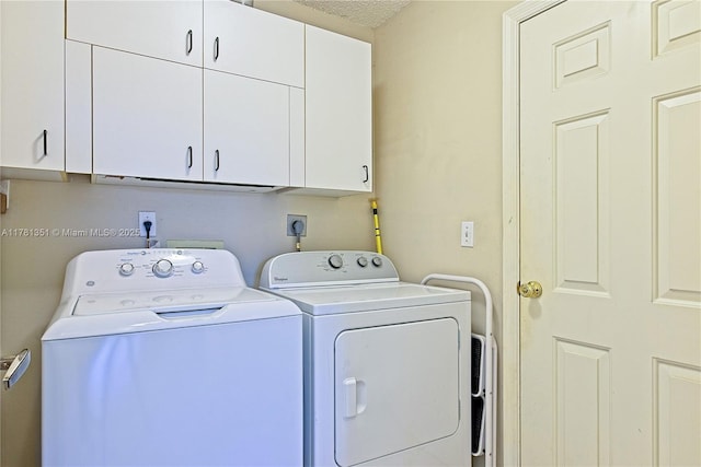 clothes washing area with cabinet space, washer and clothes dryer, and a textured ceiling