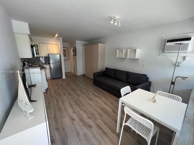 4228 N Ocean Dr Unit 17, Lauderdale By The Sea, FL 33308 - living room featuring light wood finished floors and a wall mounted air conditioner