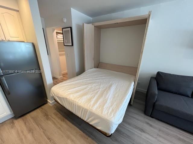 4228 N Ocean Dr Unit 17, Lauderdale By The Sea, FL 33308 - bedroom with freestanding refrigerator, light wood-style flooring, and baseboards