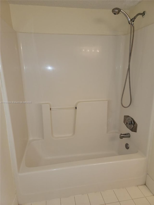bathroom featuring tile patterned flooring and  shower combination