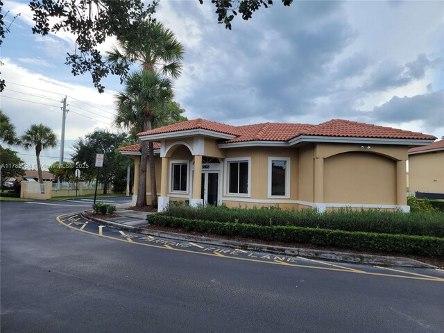 mediterranean / spanish home with stucco siding and a tiled roof