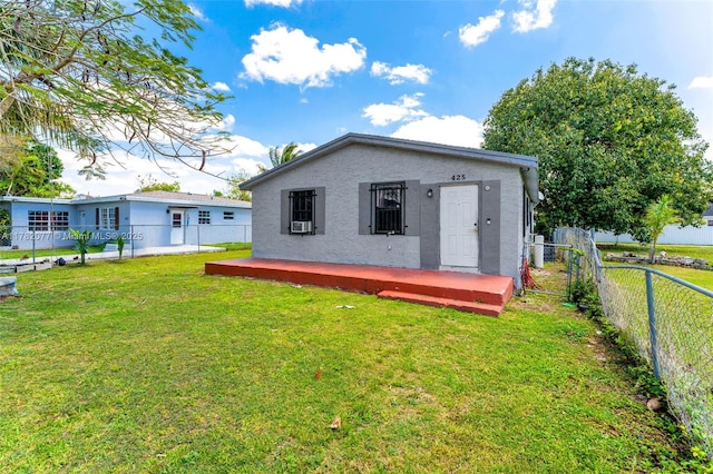 425 NW 8th Ave, Homestead, FL 33030 - rear view of property with a fenced backyard, a lawn, and stucco siding