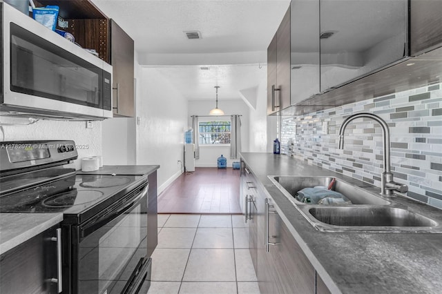 425 NW 8th Ave, Homestead, FL 33030 - kitchen with light tile patterned floors, electric range, visible vents, stainless steel microwave, and a sink