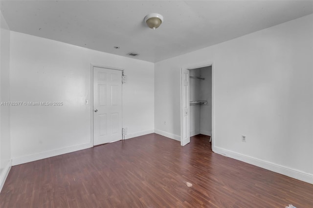 425 NW 8th Ave, Homestead, FL 33030 - unfurnished bedroom featuring visible vents, baseboards, a closet, a walk in closet, and wood finished floors