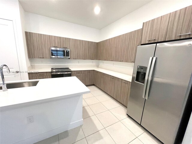 4506 SW 174th Ave, Miramar, FL 33029 - kitchen with light tile patterned floors, modern cabinets, appliances with stainless steel finishes, light countertops, and a sink