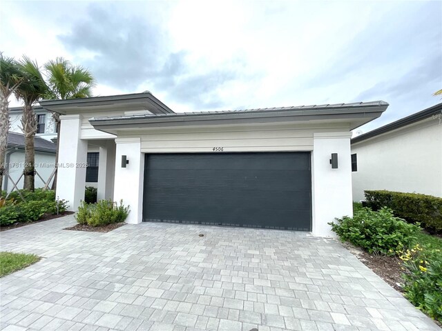 4506 SW 174th Ave, Miramar, FL 33029 - prairie-style house featuring stucco siding, decorative driveway, and an attached garage