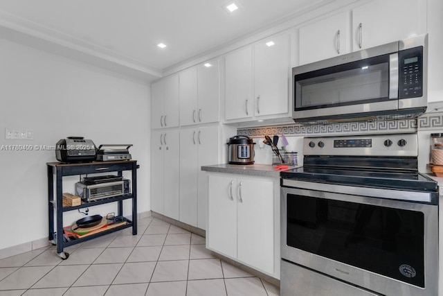 kitchen with light tile patterned floors, white cabinets, and appliances with stainless steel finishes