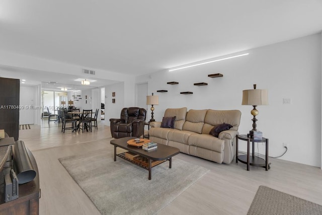 living area featuring light wood-style floors and visible vents