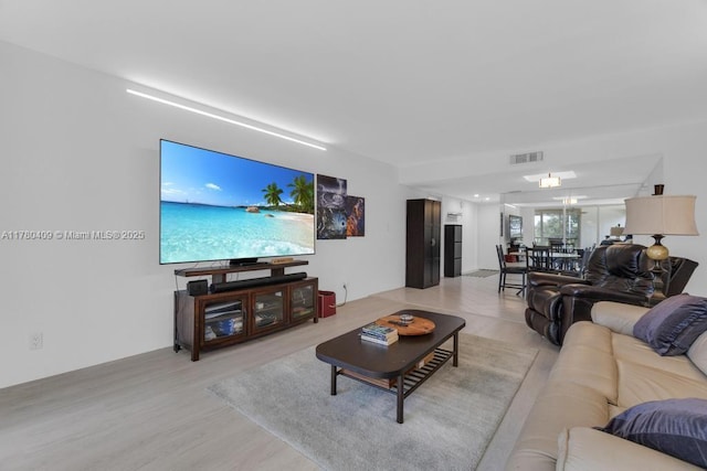 living area with visible vents and light wood-style flooring