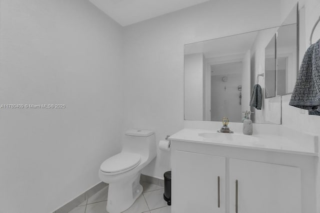 bathroom with tile patterned floors, vanity, baseboards, and toilet