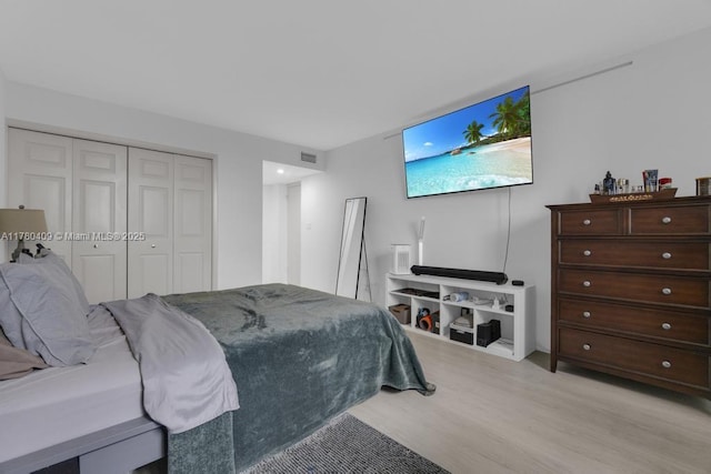 bedroom featuring visible vents, light wood-type flooring, and a closet