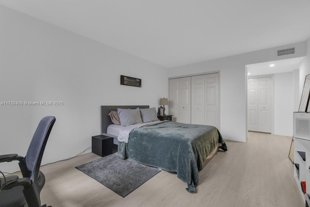 bedroom with a closet, light wood finished floors, and visible vents