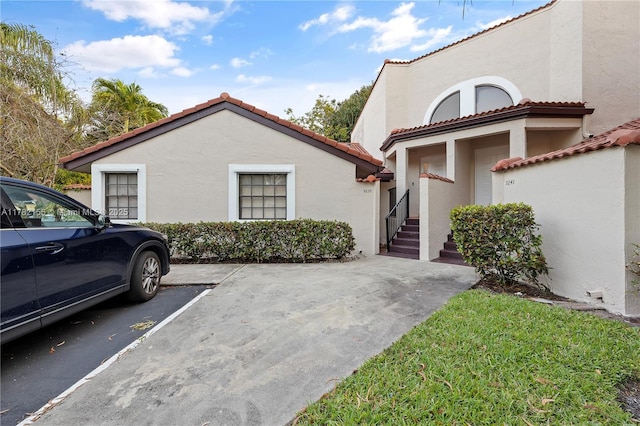 9239 W Sunrise Blvd, Plantation, FL 33322 - view of side of home featuring uncovered parking, a tiled roof, and stucco siding