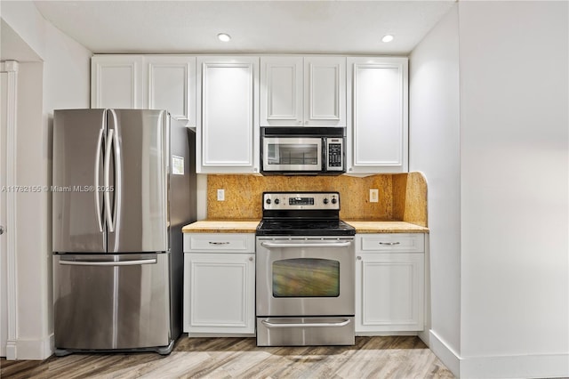 9239 W Sunrise Blvd, Plantation, FL 33322 - kitchen with light wood-style flooring, appliances with stainless steel finishes, light countertops, and white cabinets