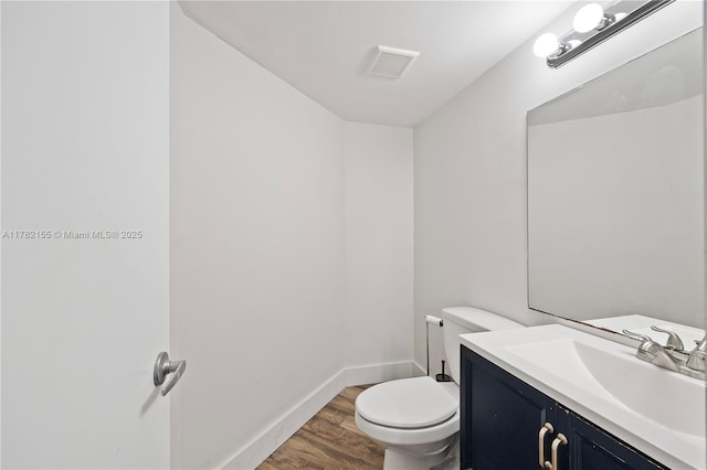 9239 W Sunrise Blvd, Plantation, FL 33322 - bathroom featuring vanity, visible vents, toilet, wood finished floors, and baseboards
