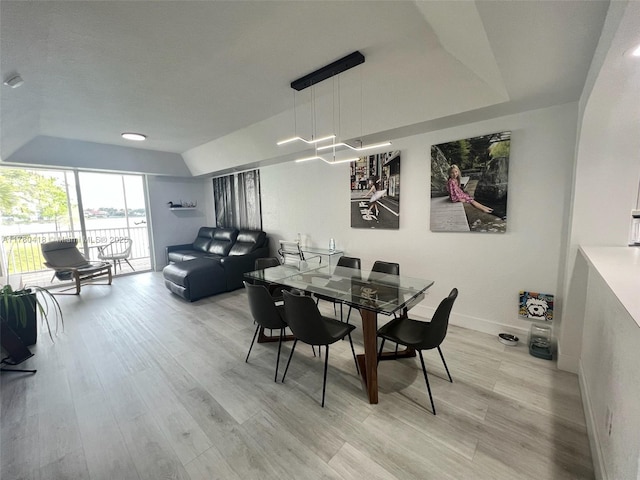 dining space with light wood finished floors and baseboards