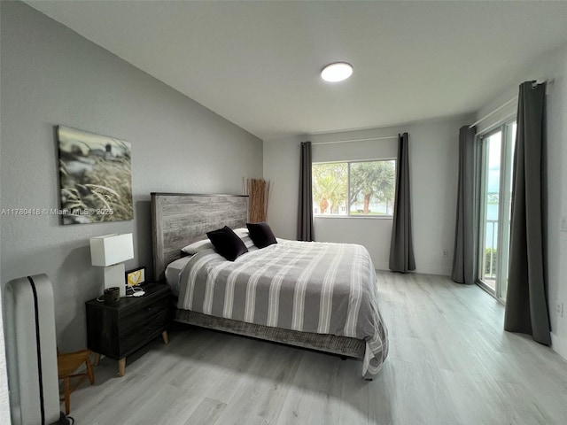 bedroom with light wood-style floors and access to outside