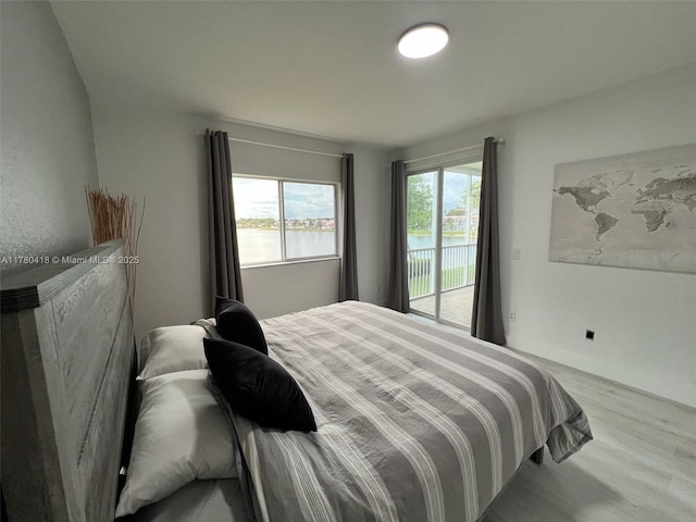 bedroom featuring access to exterior and wood finished floors