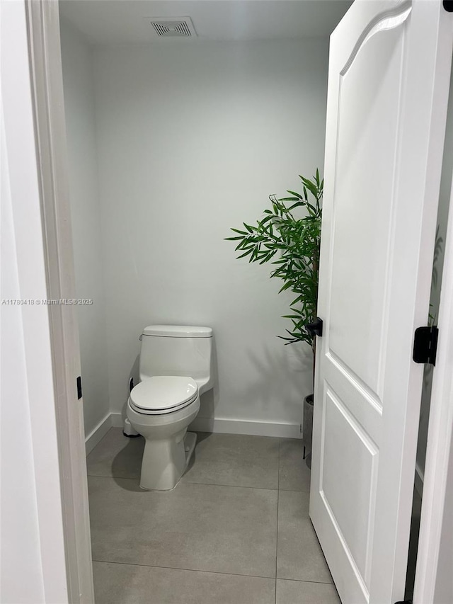bathroom featuring tile patterned floors, visible vents, baseboards, and toilet
