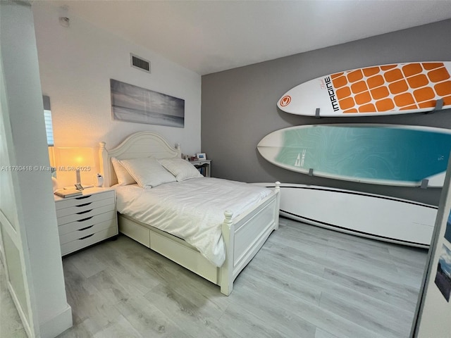 bedroom featuring visible vents and light wood-style floors