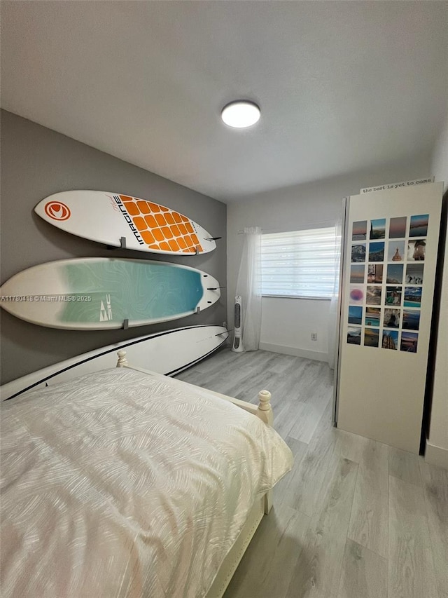 bedroom featuring baseboards and wood finished floors