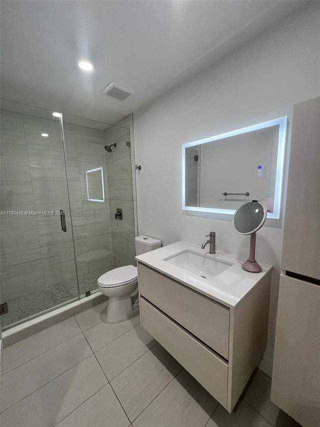 bathroom with visible vents, toilet, a shower stall, vanity, and tile patterned floors