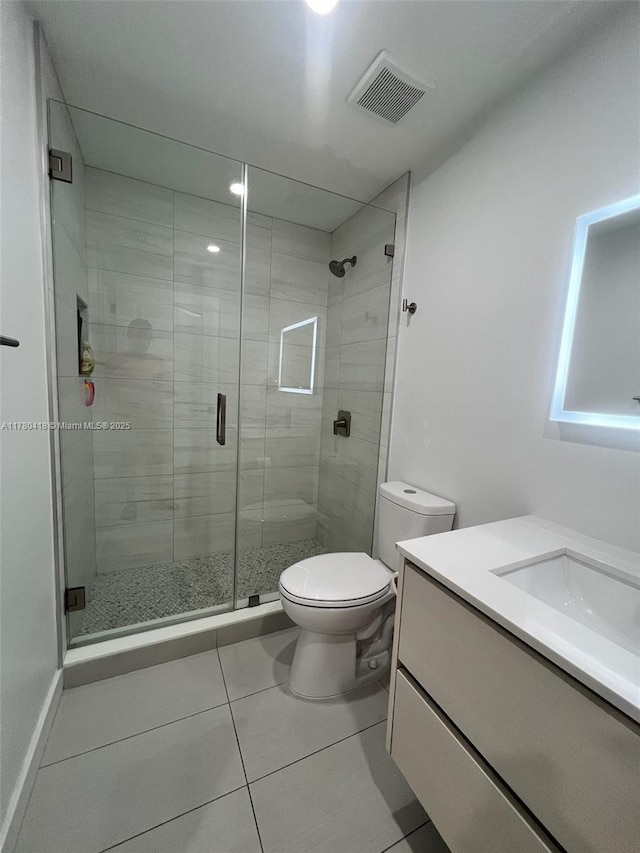 full bathroom with visible vents, toilet, a shower stall, vanity, and tile patterned flooring