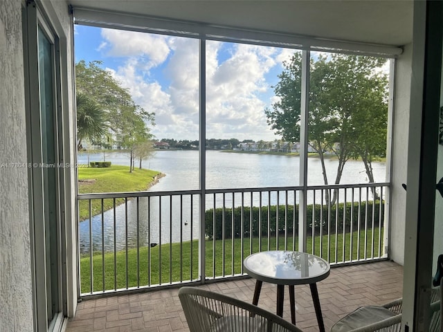 sunroom / solarium featuring a water view