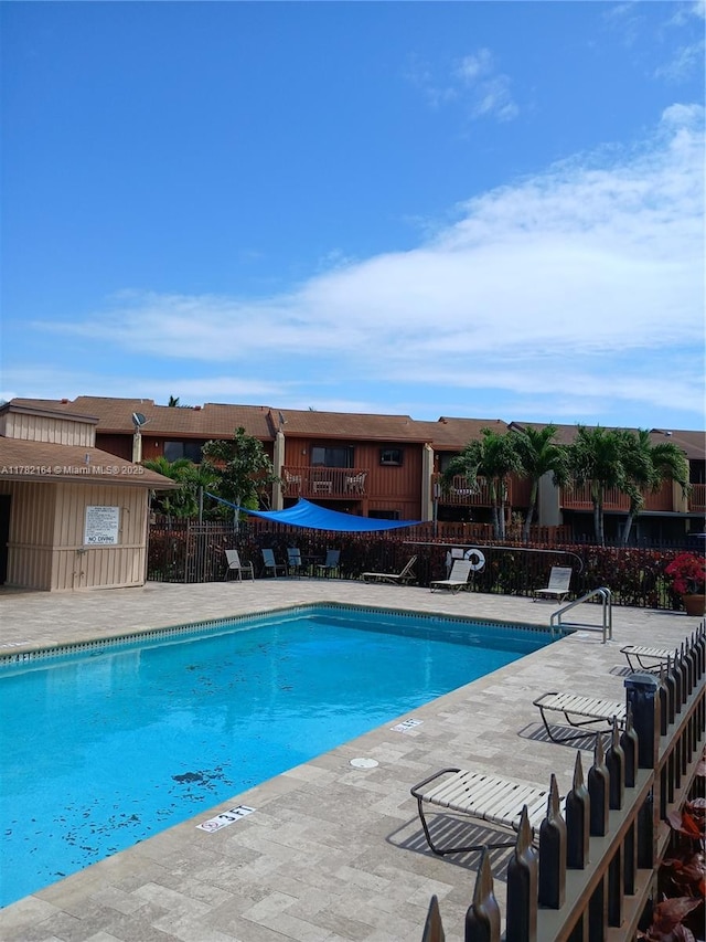 pool with a patio area and fence