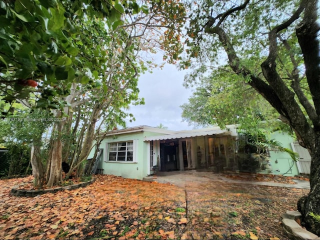 rear view of house featuring stucco siding