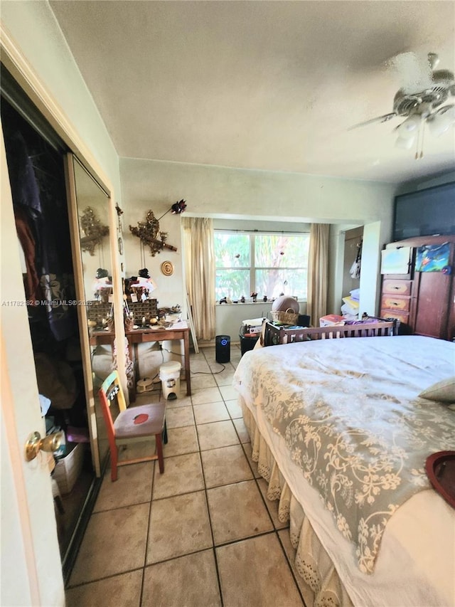 bedroom featuring light tile patterned floors, ceiling fan, and a closet