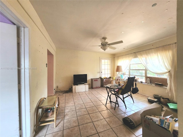 living area featuring ceiling fan and tile patterned flooring