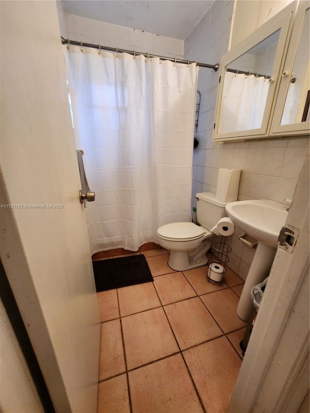 full bath featuring curtained shower, toilet, tile patterned flooring, and tile walls