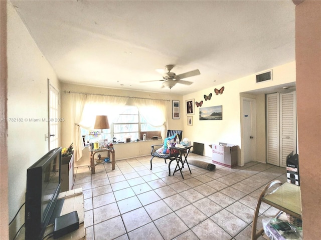living room with visible vents, a ceiling fan, and light tile patterned flooring